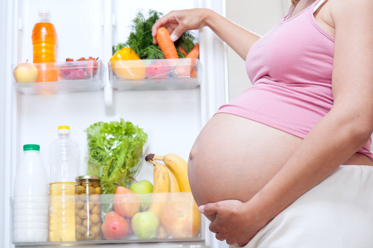 pregnant woman and refrigerator with health food