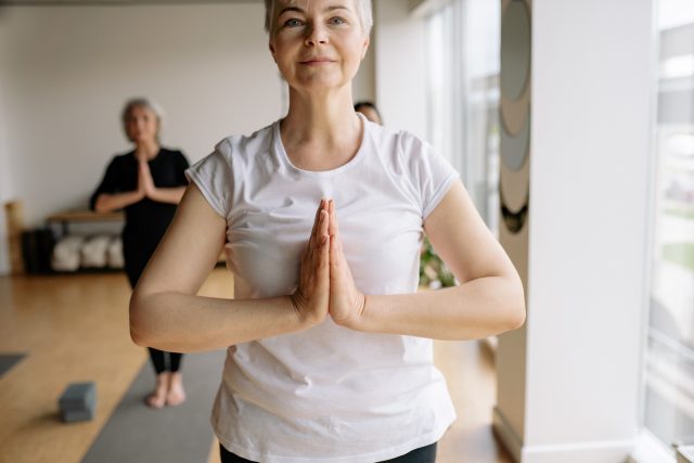 Shallow Focus Photo of a Woman in White Shirt Doing Yoga