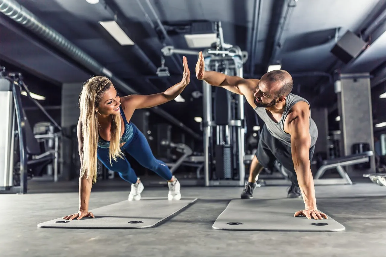 Sport couple doing plank exercise workout in fitness centrum